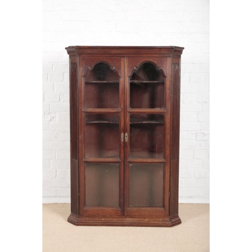 909 - A GEORGE III MAHOGANY CORNER CUPBOARD

with moulded cornice and canted fluted sides, fitted with thr... 