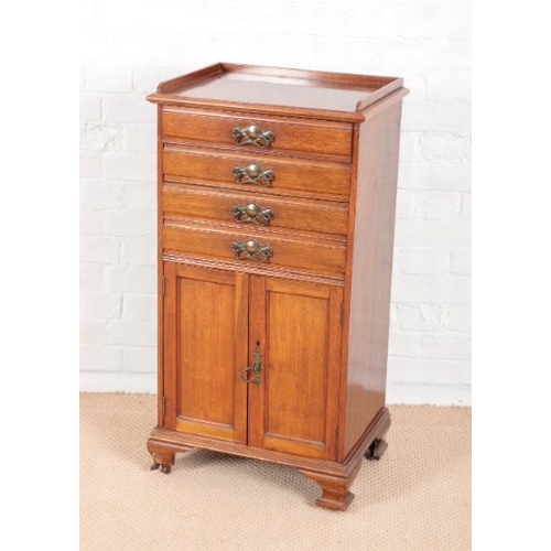 923 - AN EDWARDIAN WALNUT MUSIC CABINET

with low gallery, the four drawers with fall fronts and a cupboar... 