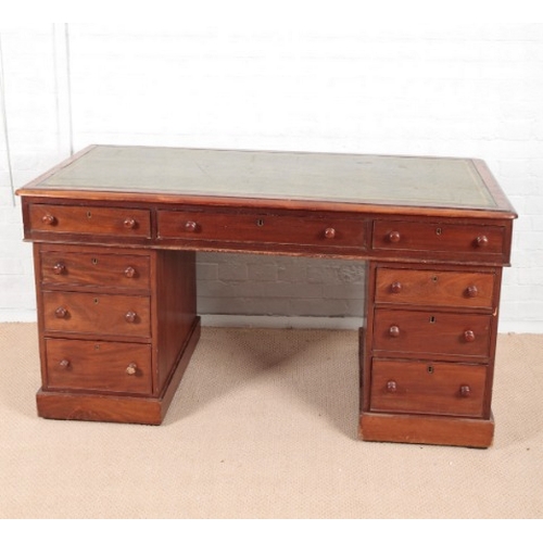 973 - A VICTORIAN MAHOGANY KNEEHOLE DESK

the top inset with green leather, fitted nine drawers with knob ... 