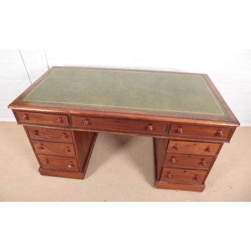 973 - A VICTORIAN MAHOGANY KNEEHOLE DESK

the top inset with green leather, fitted nine drawers with knob ... 