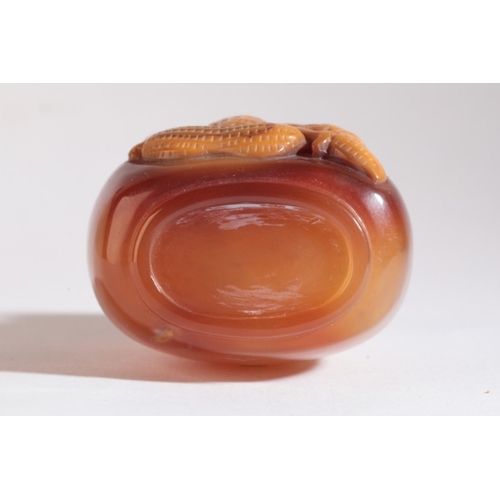 111 - A CHINESE AGATE SNUFF BOTTLE

probably 19th century, the ochre skin to the front carved in high reli... 