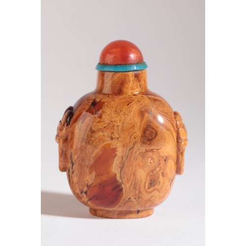 46 - A CHINESE ROOT AMBER SNUFF BOTTLE

18th/19th century, carved to each shoulder with lion mask and sus... 