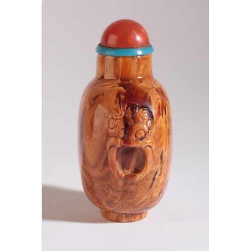 46 - A CHINESE ROOT AMBER SNUFF BOTTLE

18th/19th century, carved to each shoulder with lion mask and sus... 