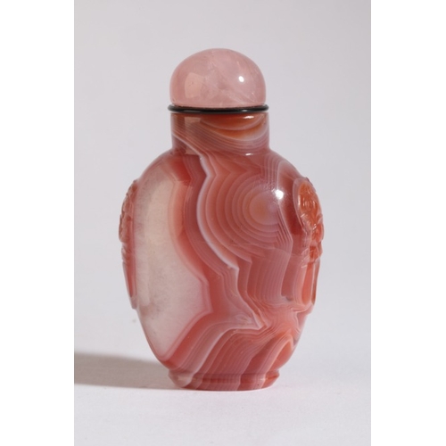 87 - A CHINESE AGATE SNUFF BOTTLE

19th century, with white striations to the red stone, carved mask and ... 