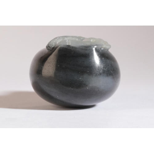 90 - A CHINESE JADE SNUFF BOTTLE

19th century, the 'black' nephrite body carved to the front with an eag... 