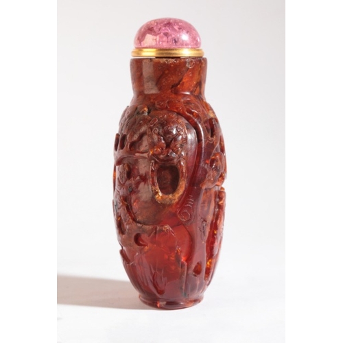 96 - A CHINESE AMBER SNUFF BOTTLE

likely 18th/19th century, carved to the front with sages amongst pine ... 