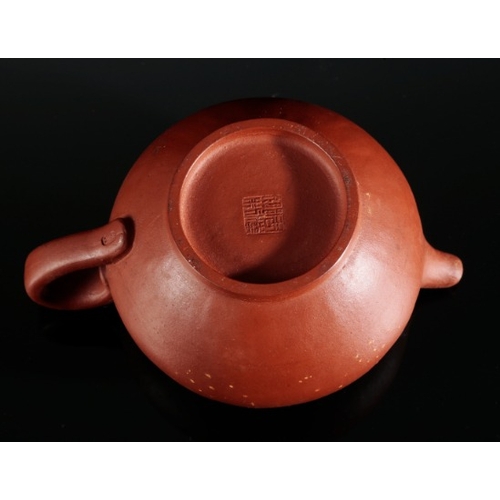 381 - A CHINESE YIXING TEAPOT

with an impressed seal mark to the base, 9cm high