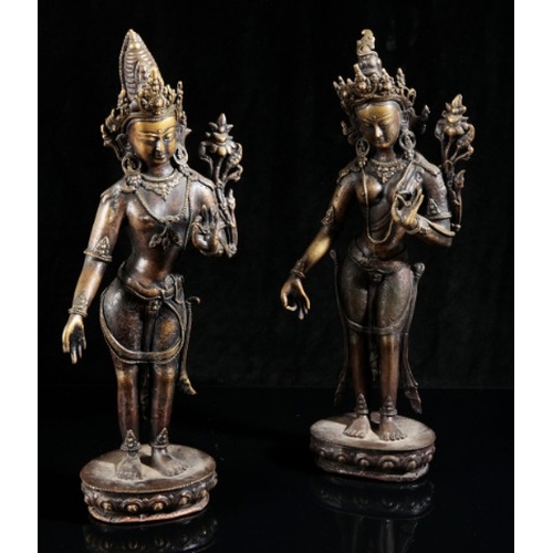 488 - A NEAR PAIR OF NEPALESE BRONZE FIGURES OF TARA

20th century, both cast standing on a single lotus b... 