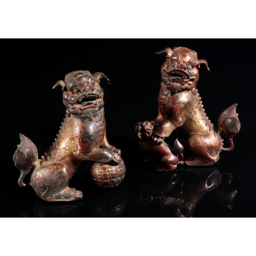 492 - AN OPPOSING PAIR OF GILT METAL LION DOG CENSERS

20th century, each with hinged necks and lifting he... 