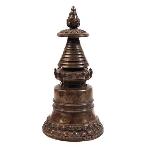 502 - A TIBETAN BRONZE STUPA

possibly 13th/14th century, of bell shaped form, the foliate finial above a ... 