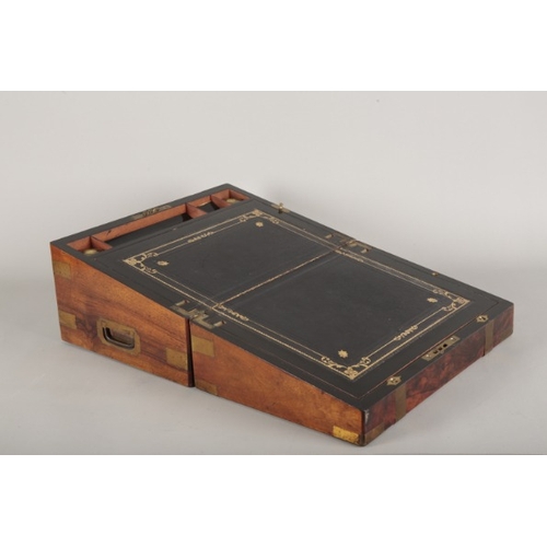 12 - A VICTORIAN MAHOGANY WRITING SLOPE

the lid with brass banding, opening to a tooled leather writing ... 