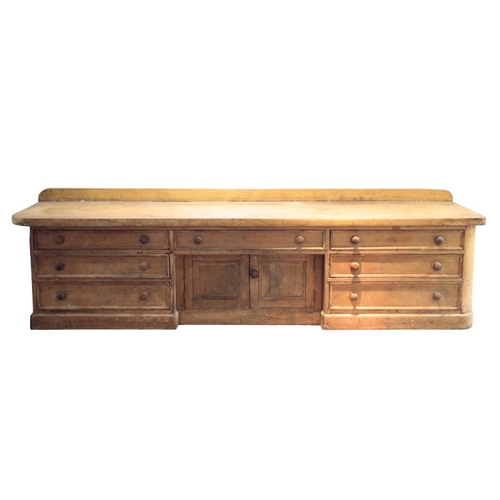 175 - A 19TH CENTURY STRIPPED PINE HABERDASHERY COUNTER

with two plank top, fitted seven drawers and cent... 