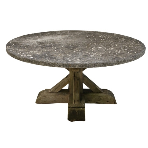 325 - A LARGE RUSTIC CIRCULAR GARDEN TABLE

the top of weathered hewn stone resting atop a wooden block ce... 