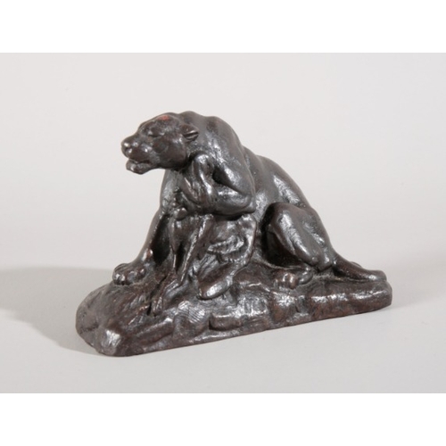 56 - AN UNSIGNED PATINATED IRON SCULPTURE OF A PANTHER CLUTCHING PREY IN ONE PAW

realistically posed sna... 