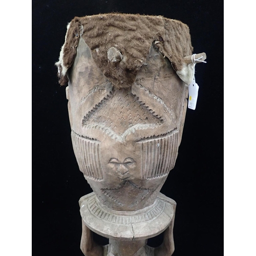 235 - AN AFRICAN PEG DRUM WITH FIGURAL SUPPORT

the drum carved with three faces, possibly Baule, 84cm hig... 