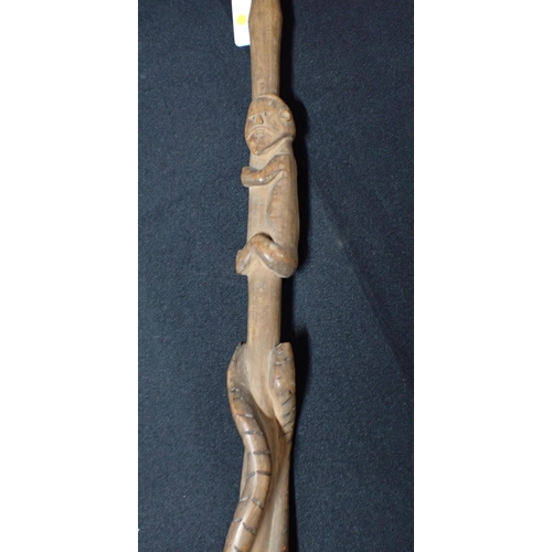 273 - AN AFRICAN STAFF OR WALKING STICK CARVED WITH SNAKES AND CLIMBING FIGURES

with head terminal 117cm ... 