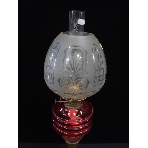 36 - A VICTORIAN OIL LAMP WITH FACETED CRANBERRY GLASS FONT

and etched beehive-shape shade