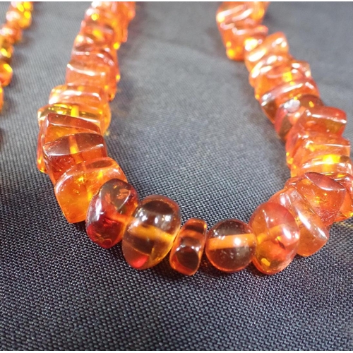 409 - AN AMBER NECKLACE, OF IRREGULAR BEADS

with screw-clasp 58cm long, another smaller, two brooches, a ... 