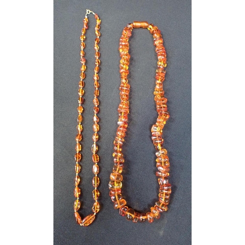 409 - AN AMBER NECKLACE, OF IRREGULAR BEADS

with screw-clasp 58cm long, another smaller, two brooches, a ... 