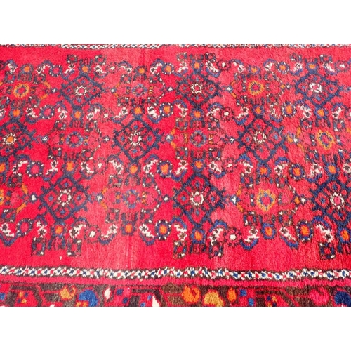 741 - A LONG COUNTRY HOUSE STYLE RUNNER

red ground, 83 x 400cm plus fringes (one corner cut)