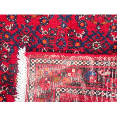 741 - A LONG COUNTRY HOUSE STYLE RUNNER

red ground, 83 x 400cm plus fringes (one corner cut)