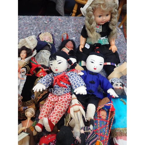 77 - A LARGE COLLECTION OF WORLD COSTUME DOLLS

including some older, one with a wax head, some bisque he... 