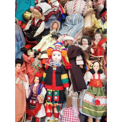 77 - A LARGE COLLECTION OF WORLD COSTUME DOLLS

including some older, one with a wax head, some bisque he... 