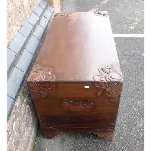 780 - A LARGE CAMPHORWOOD TRUNK

with foliate carving to the corners, and stepped bracket feet 105cm wide