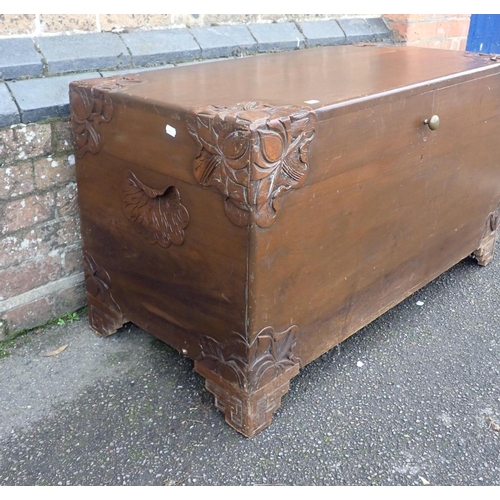 780 - A LARGE CAMPHORWOOD TRUNK

with foliate carving to the corners, and stepped bracket feet 105cm wide