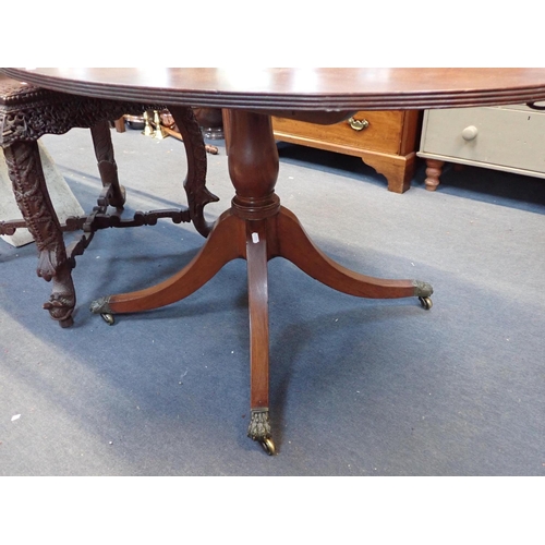 801 - A REGENCY MAHOGANY OVAL BREAKFAST TABLE

with tilt top, and quadruped base, with lion's paw castors ... 