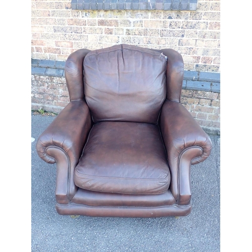 830 - A THOMAS LLOYD BROWN LEATHER CLUB STYLE WING ARMCHAIR

on turned feet with brass castors 97cm wide (... 