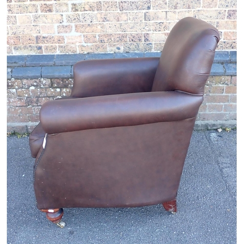 831 - A THOMAS LLOYD STUDDED BROWN LEATHER CLUB STYLE ARMCHAIR

with turned front legs and brass castors 8... 