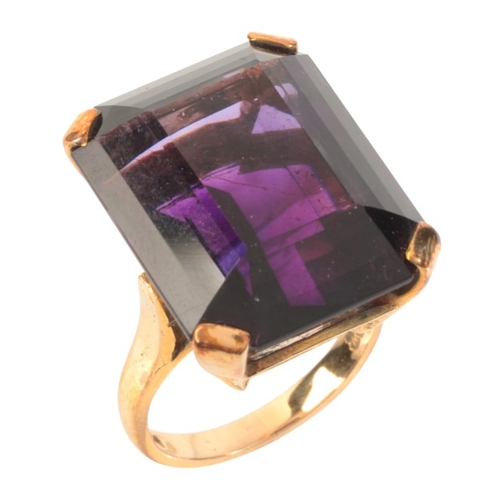 16 - AN AMETHYST COCKTAIL RING

in 9ct gold, set with a step cut amethyst of c.26.99 carats, full British... 