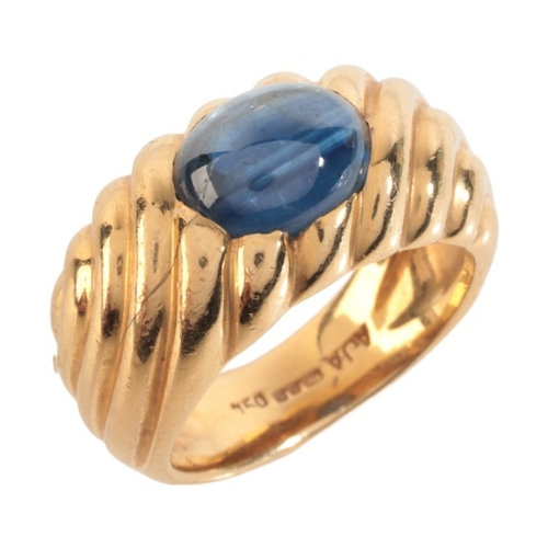 27 - A SAPPHIRE DRESS RING

in 18ct gold, set with a sapphire cabochon of c.3.17 carats, over a stylised ... 