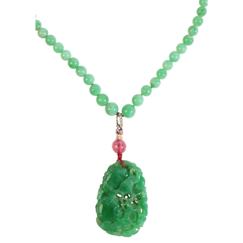 291 - A JADE NECKLACE

comprising a series of graduating jadeite jade beads, suspending a carved jadeite j... 