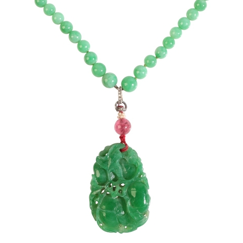 291 - A JADE NECKLACE

comprising a series of graduating jadeite jade beads, suspending a carved jadeite j... 