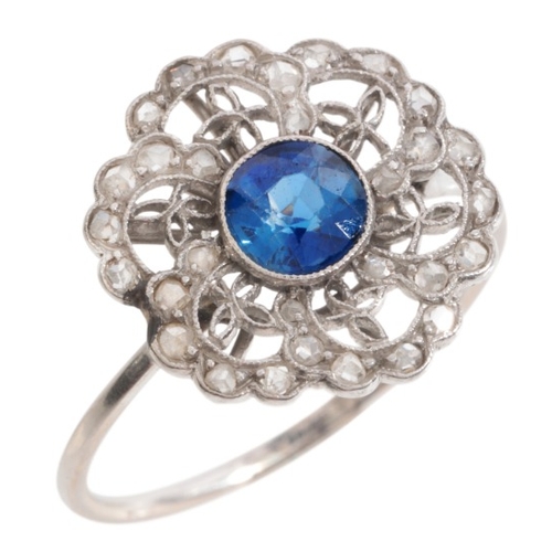 35 - A SAPPHIRE AND DIAMOND CLUSTER RING

in platinum, set with a round cut sapphire of c.0.60, to an ope... 