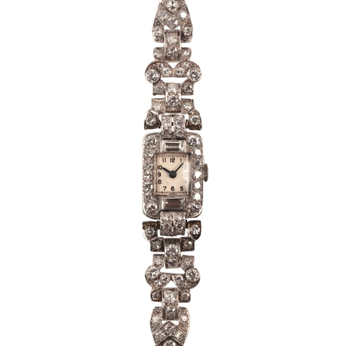 566 - A LADY'S DIAMOND AND PLATINUM COCKTAIL WATCH

with manual wind movement, the case and bracelet encru... 