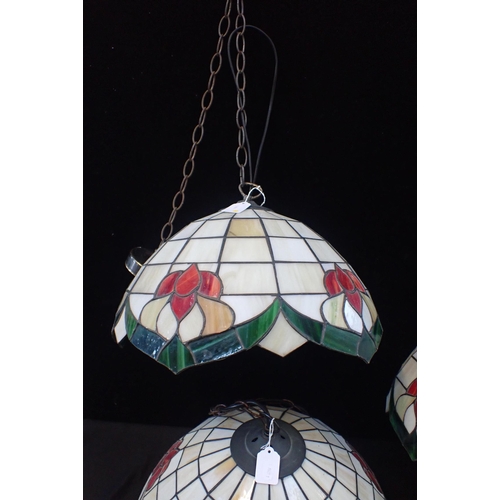 167 - A SET OF TIFFANY STYLE GLASS LIGHTS

Three hanging ceiling lamps, 40cm diam, with three wall lamps, ... 