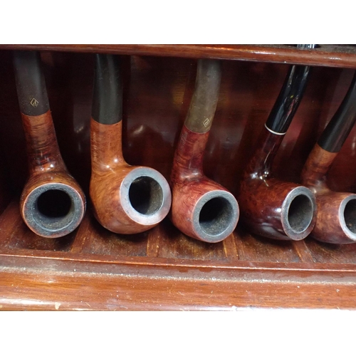 181 - A MAHOGANY PIPE RACK WITH TAMBOUR FRONT

with a collection of vintage pipes and smoking accessories