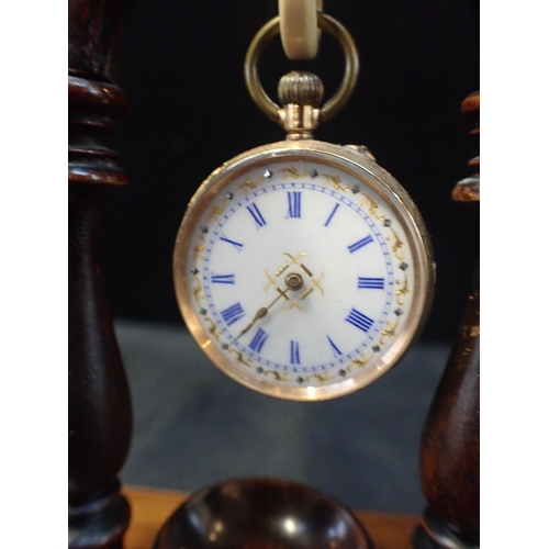 341 - A 19th CENTURY ROSEWOOD POCKET WATCH STAND

17cm high, with a ladies' gold coloured metal keyless le... 