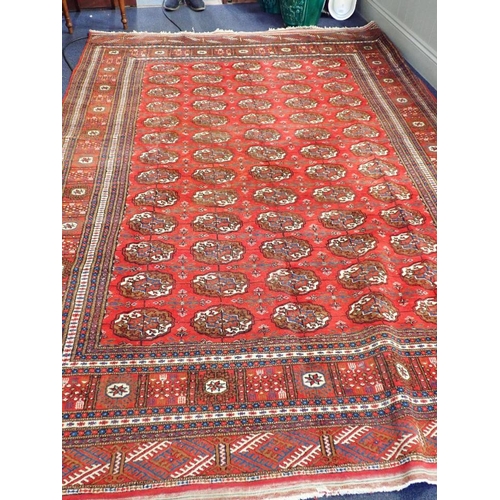 527 - A BOKHARA CARPET OF TURKOMAN STYLE

woven in colours with five rows of thirteen guls, on a cochineal... 