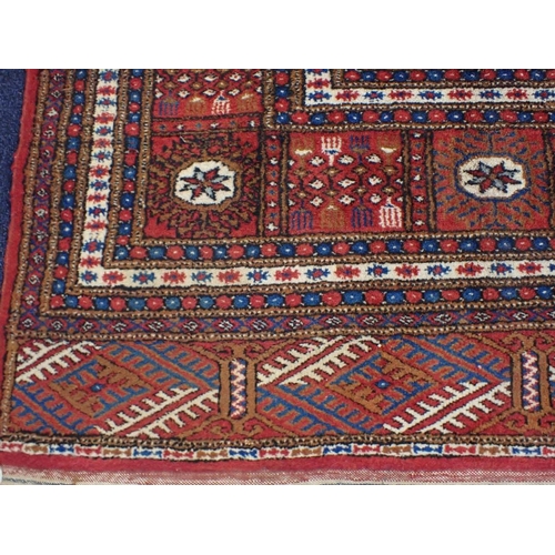 527 - A BOKHARA CARPET OF TURKOMAN STYLE

woven in colours with five rows of thirteen guls, on a cochineal... 