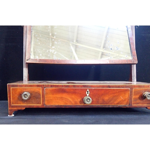 559 - A GEORGE III MAHOGANY DRESSING MIRROR

the rectangular plate on reeded square supports, the base wit... 