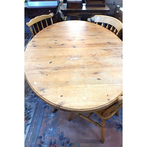 583 - A PINE OVAL KITCHEN TABLE

106 x 152cm, and three beech Windsor type kitchen chairs, one with arms