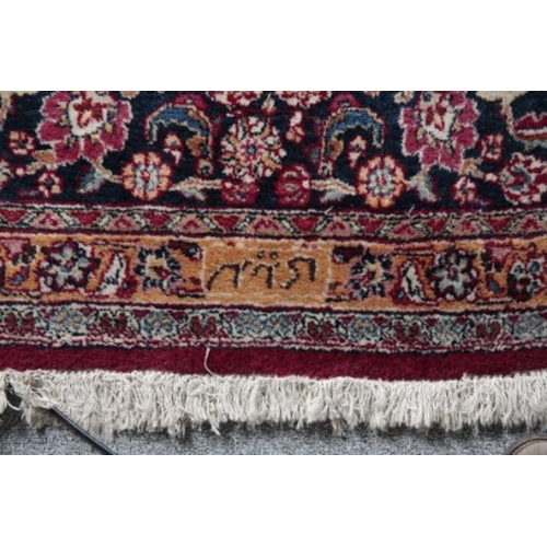 314 - A LARGE SIGNED PERSIAN CARPET

20th century, with a central floral medallion on a rich red ground, w... 