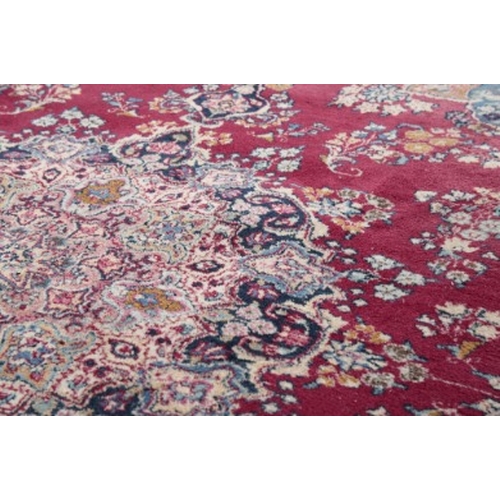 314 - A LARGE SIGNED PERSIAN CARPET

20th century, with a central floral medallion on a rich red ground, w... 