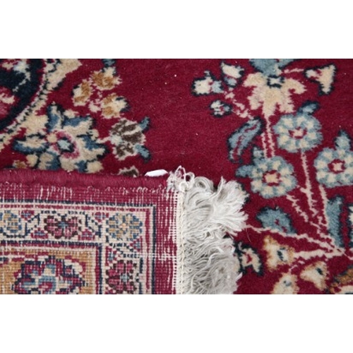 314 - A LARGE SIGNED PERSIAN CARPET

20th century, with a central floral medallion on a rich red ground, w... 