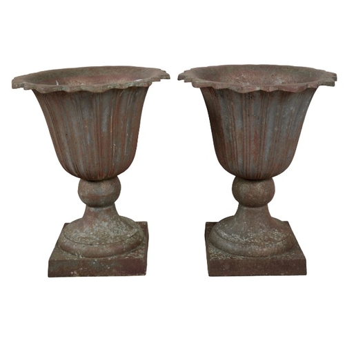 323 - A PAIR OF CAST IRON GARDEN URNS

of campana shape, with fluted tapered bodies on square plinth bases... 