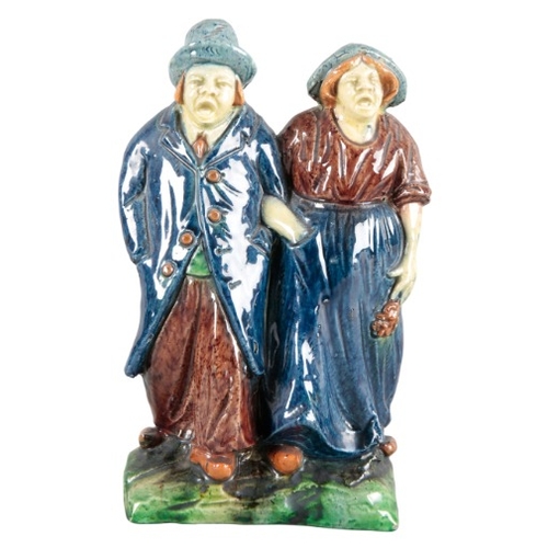 41 - TWO MAJOLICA POTTERY FIGURES

19th century, one modelled as a father wearing a tall hat holding his ... 